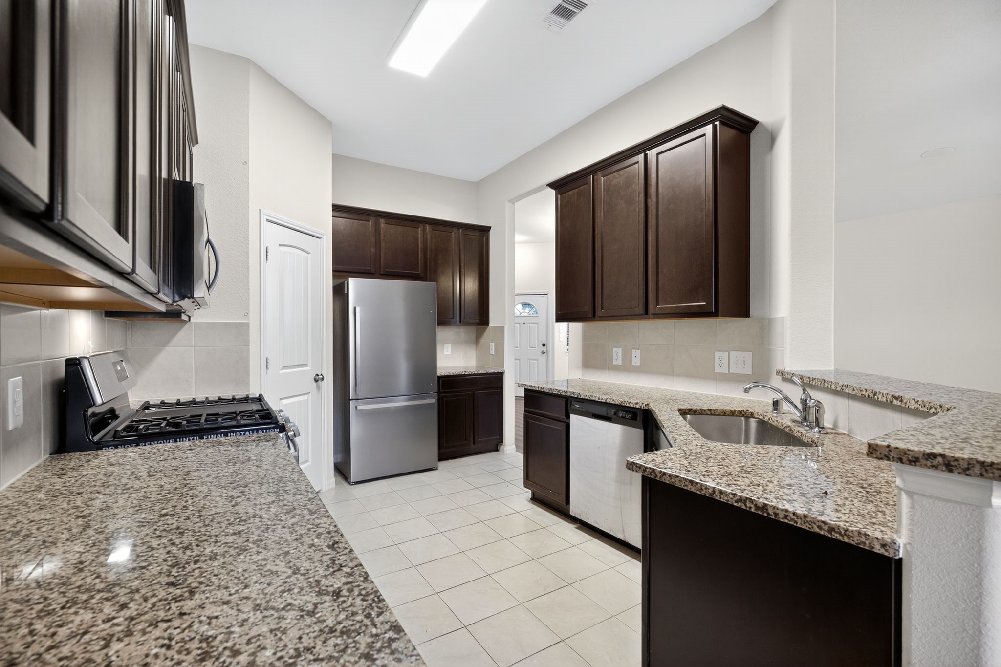 22514 Rustic Valley Court Porter, TX 77365 - Photo 12 of 33 a kitchen with a sink stove and refrigerator