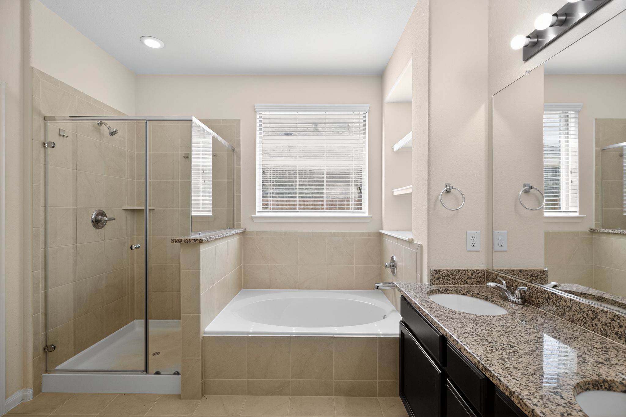 22514 Rustic Valley Court Porter, TX 77365 - Photo 23 of 33 a bathroom with a granite countertop bathtub shower sink and mirror