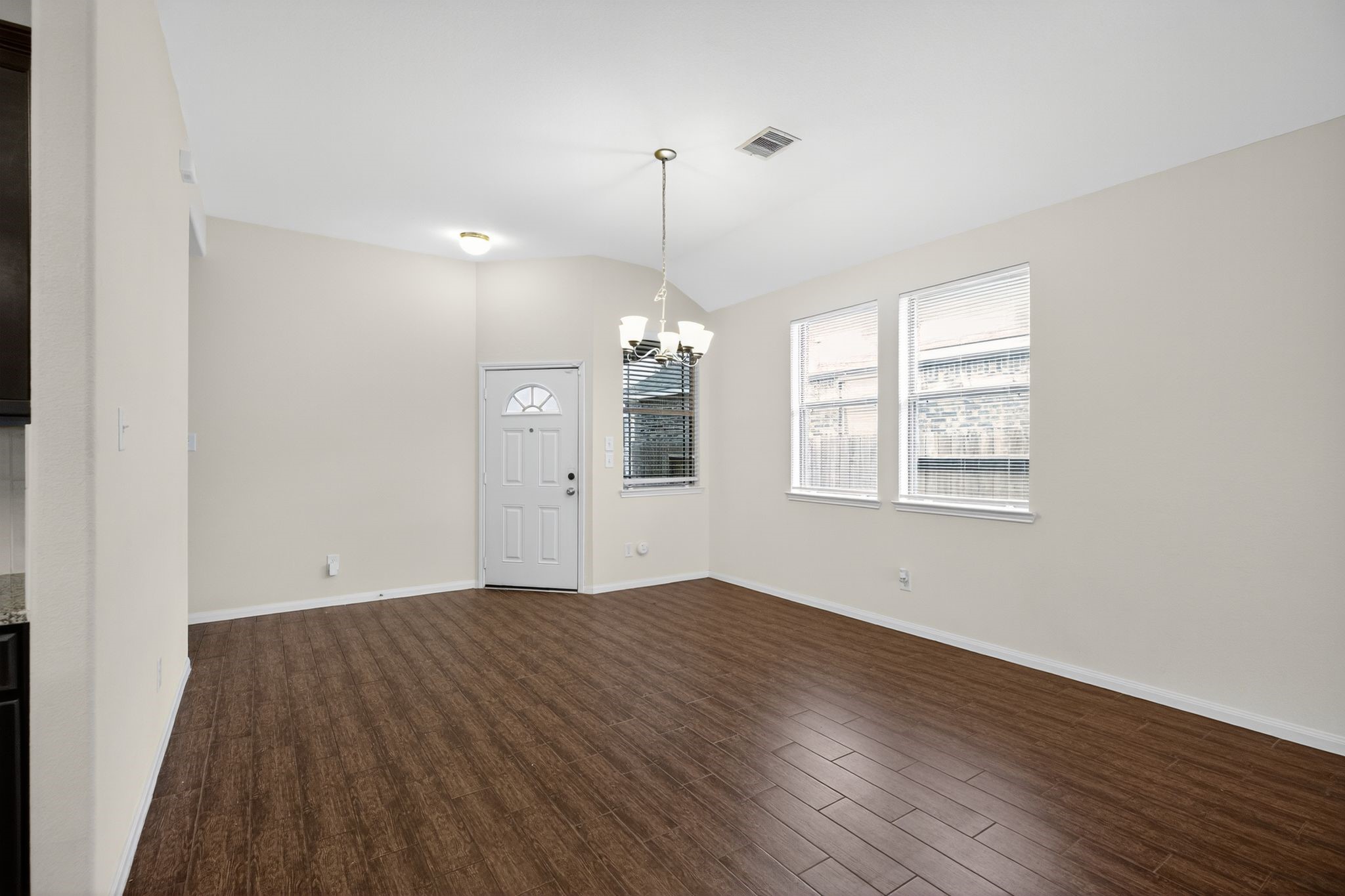 22514 Rustic Valley Court Porter, TX 77365 - Photo 8 of 33 an empty room with wooden floor chandelier and windows