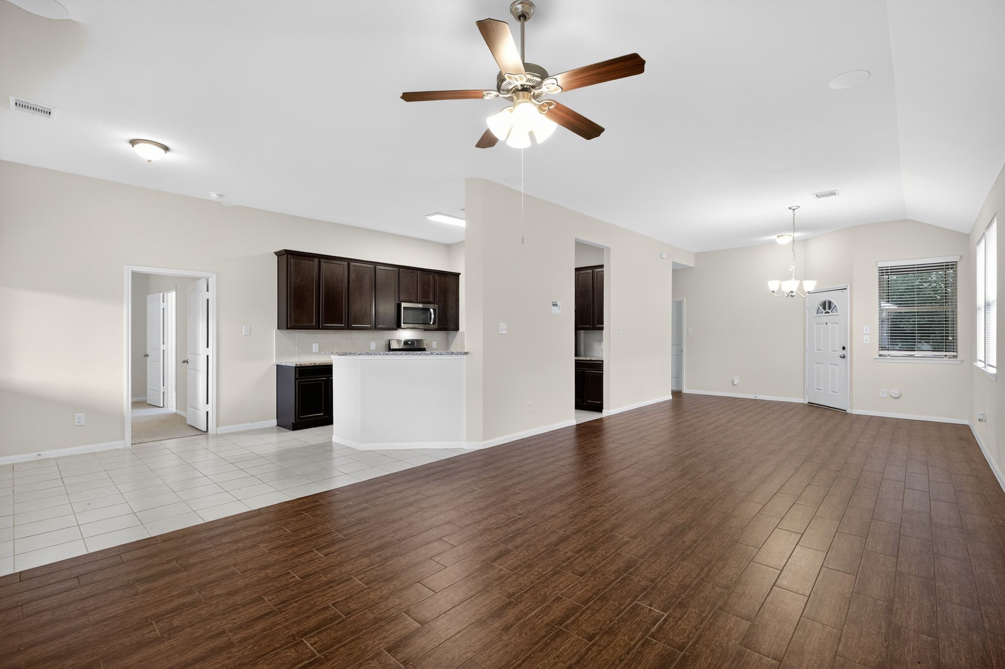 22514 Rustic Valley Court Porter, TX 77365 - Photo 10 of 33 a view of a kitchen with a microwave and a ceiling fan