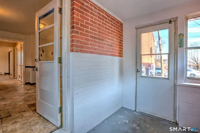 a view of a hallway with wooden floor and a living room
