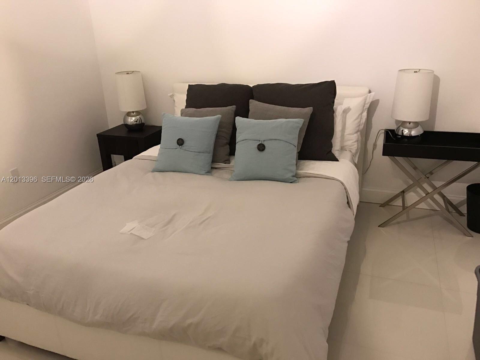 1401 Bay Road, Unit 513 Miami Beach, FL 33139 - Photo 9 of 12 a large bed sitting in a bedroom next to a window