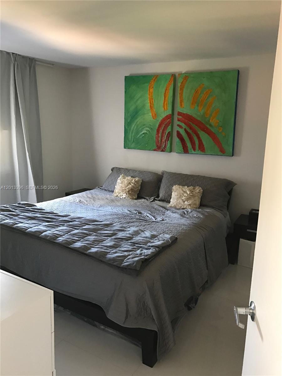 1401 Bay Road, Unit 513 Miami Beach, FL 33139 - Photo 10 of 12 a bedroom with a bed and painting on the wall