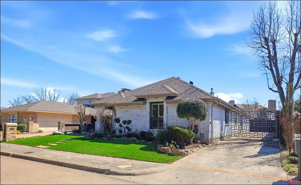 a front view of a house with a yard and potted plants
