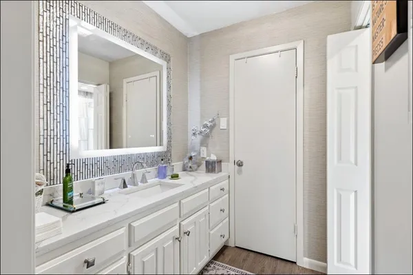 a bathroom with a double vanity sink mirror and next to a white cabinet