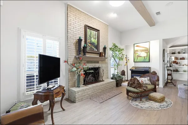 a living room with furniture a fireplace and a flat screen tv