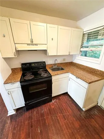 a kitchen with a stove a sink and a window