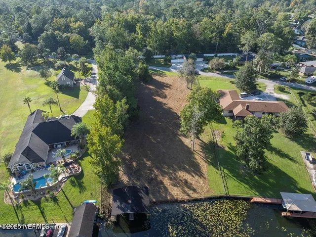 an aerial view of a house with swimming pool patio and lake view