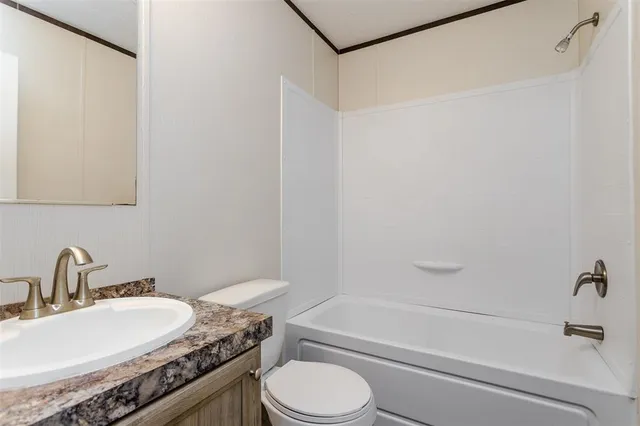 a bathroom with a granite countertop sink toilet a mirror and shower
