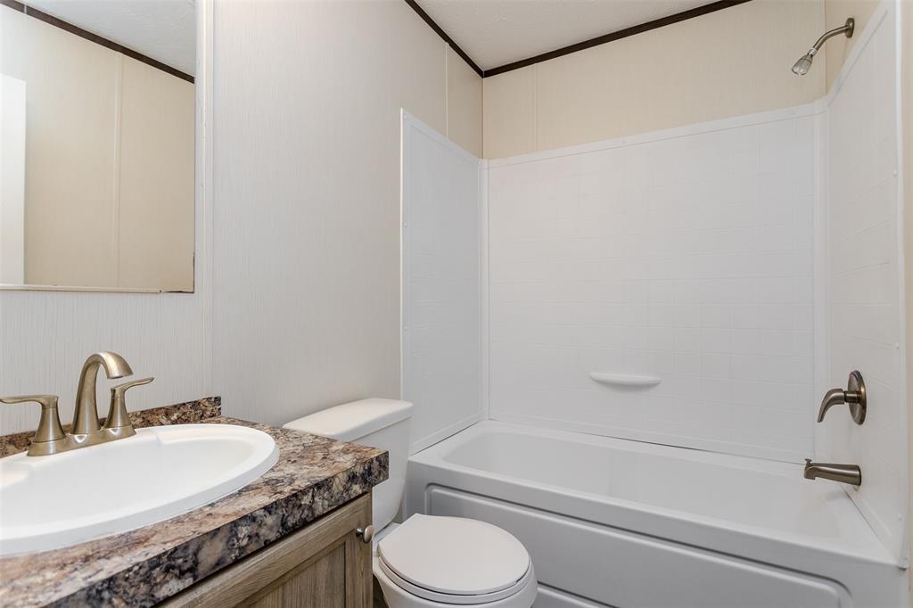2900 Interstate 35, Unit 197 Waco, TX 76706 - Photo 20 of 24 a bathroom with a granite countertop sink toilet a mirror and shower