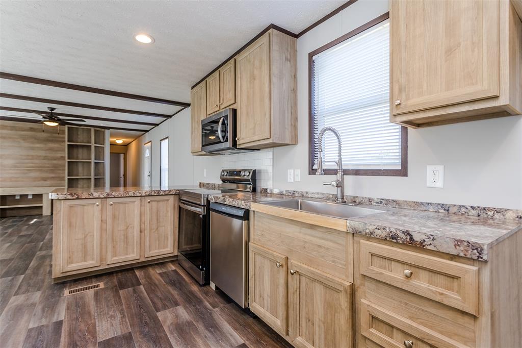 2900 Interstate 35, Unit 197 Waco, TX 76706 - Photo 2 of 24 a kitchen with granite countertop a sink stainless steel appliances and cabinets