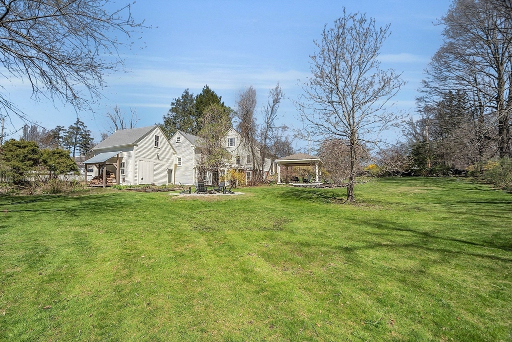 47 Center Bridge Road Lancaster, MA 01523 - Photo 39 of 42 a view of a white house with a big yard plants and large trees