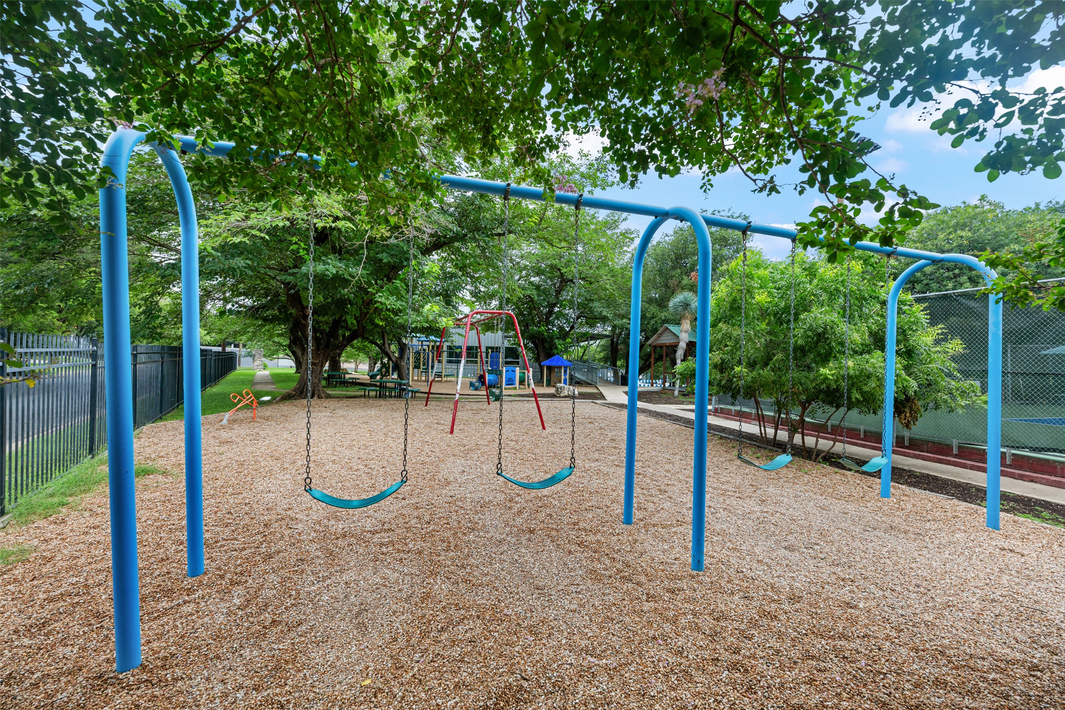 8900 Point W Drive Austin, TX 78759 - Photo 40 of 40 A well-maintained community playground awaits, featuring swings and ample space for enjoyment.