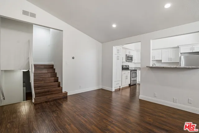 a view of kitchen with wooden floor and electronic appliances