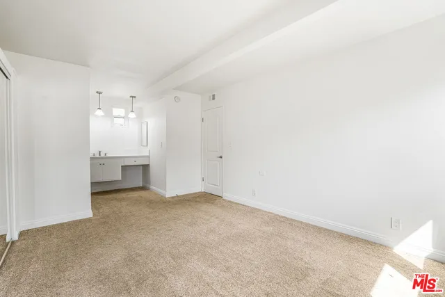 a view of an empty room with a kitchen