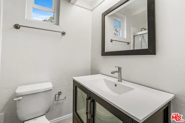 a bathroom with a sink a toilet and mirror