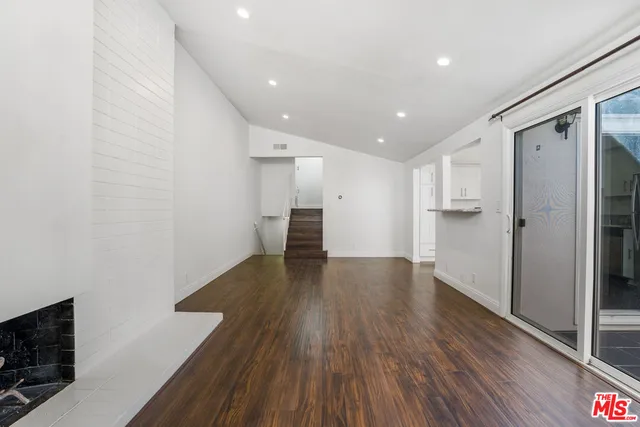a view of a big room with wooden floor and windows