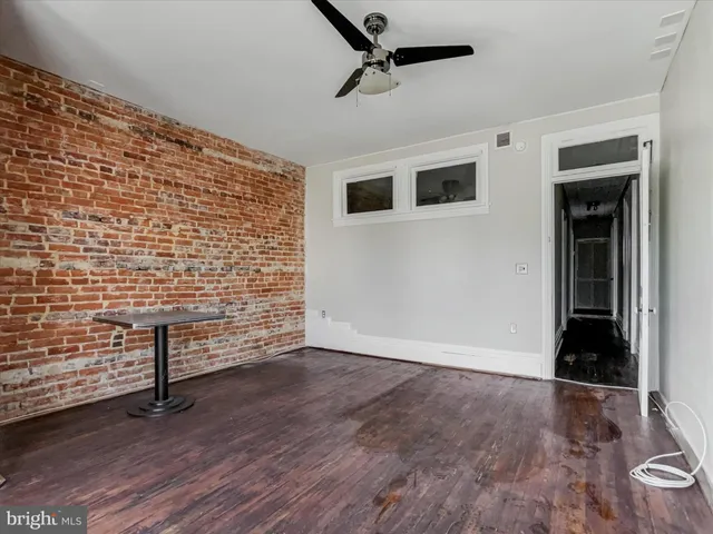 a utility room with stainless steel appliances wooden floors and view living room
