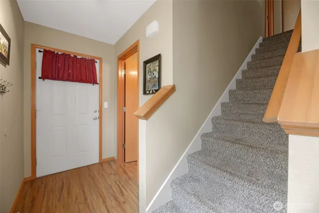 a view of a hallway with wooden floor and staircase