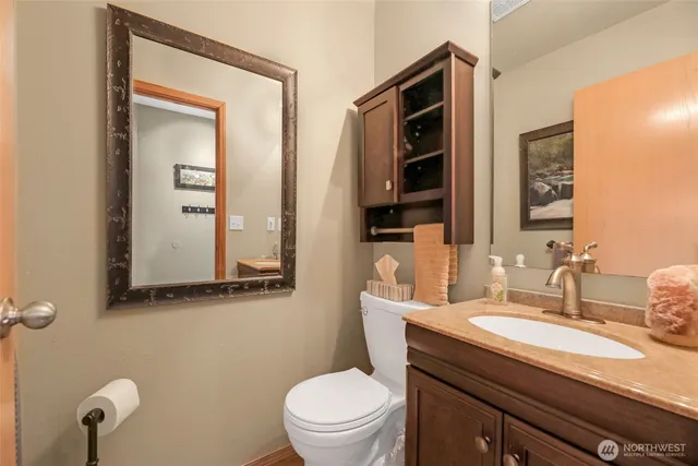 a bathroom with a granite countertop sink mirror and toilet
