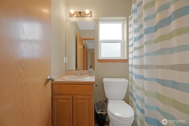 a bathroom with a toilet a sink and a shower curtain