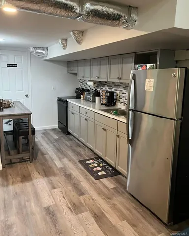 a kitchen with stainless steel appliances a refrigerator a sink a stove top oven a counter space and cabinets