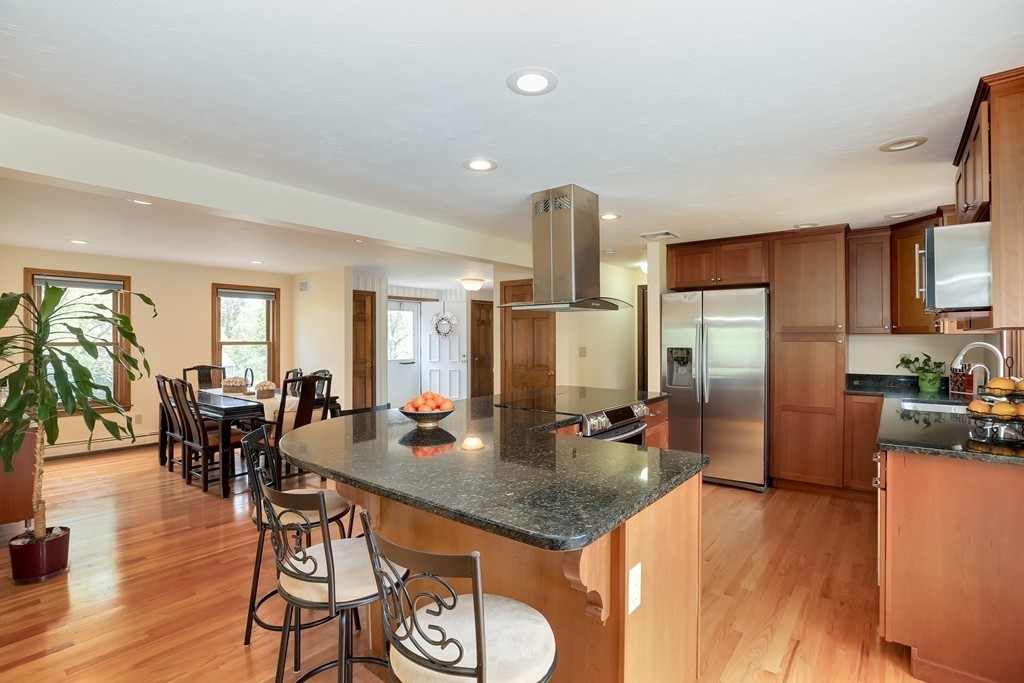 15 Barrett Road Lexington, MA 02421 - Photo 8 of 30 a kitchen with stainless steel appliances granite countertop a kitchen island a table and chairs in it