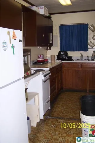 a kitchen with stainless steel appliances granite countertop a refrigerator sink a stove and a microwave