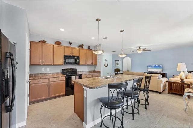 a kitchen with stainless steel appliances granite countertop a sink a stove and refrigerator
