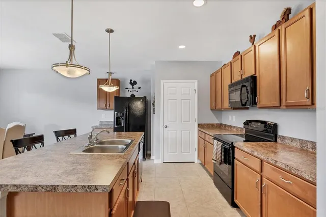 a kitchen with stainless steel appliances granite countertop a sink a stove and a wooden floor