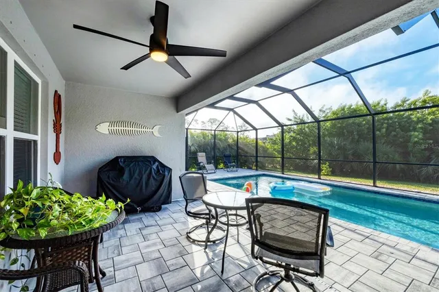 a view of a swimming pool with a patio and a yard
