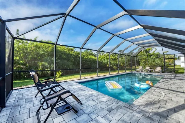 a view of a backyard with swimming pool and sitting area
