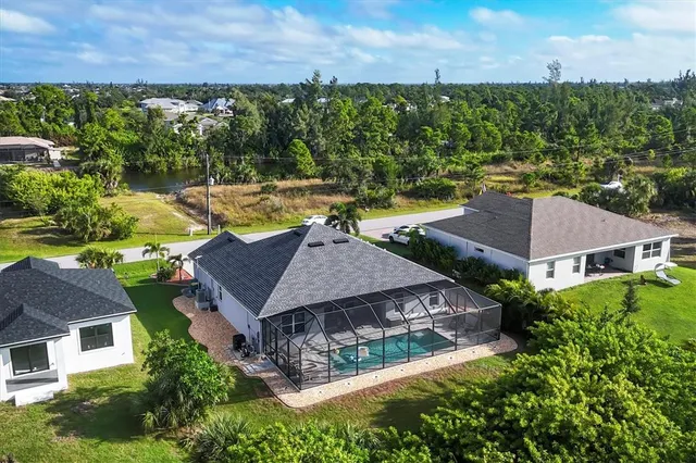 an aerial view of residential houses with outdoor space and trees