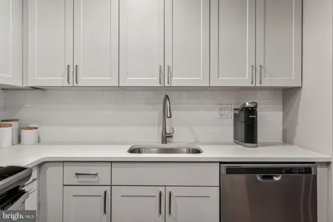 a kitchen with white cabinets and a sink
