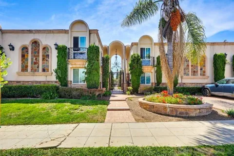 a front view of a house with a garden and plants