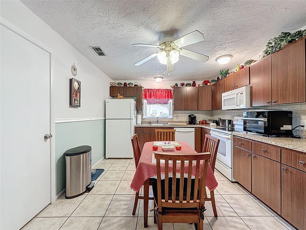 7135 Trenton Place New Port Richey, FL 34653 - Photo 12 of 50 a kitchen with stainless steel appliances granite countertop a refrigerator and microwave