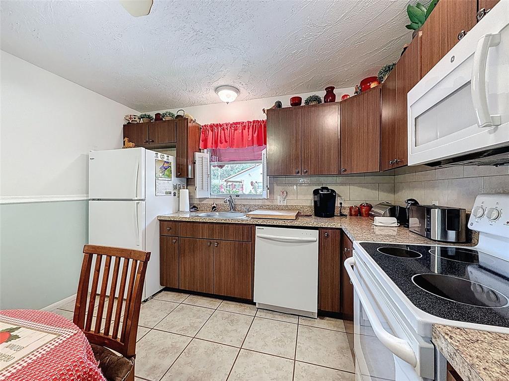 7135 Trenton Place New Port Richey, FL 34653 - Photo 13 of 50 a kitchen with stainless steel appliances granite countertop a sink stove and refrigerator