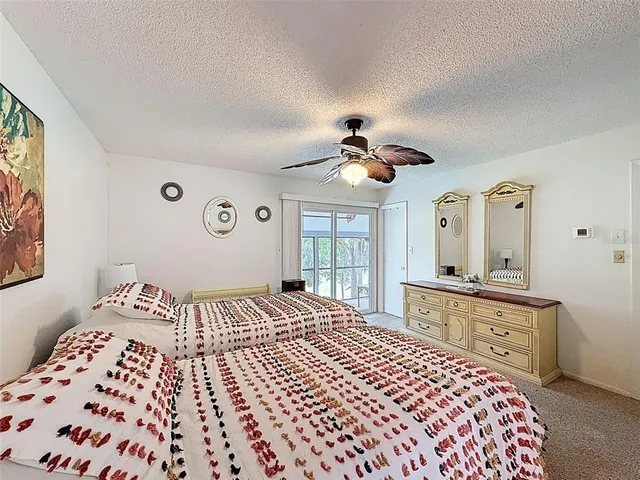 a bathroom with a granite countertop sink a toilet a large mirror and shower