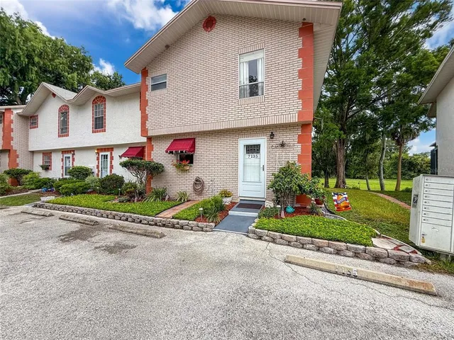 a view of a white house with a yard and plants