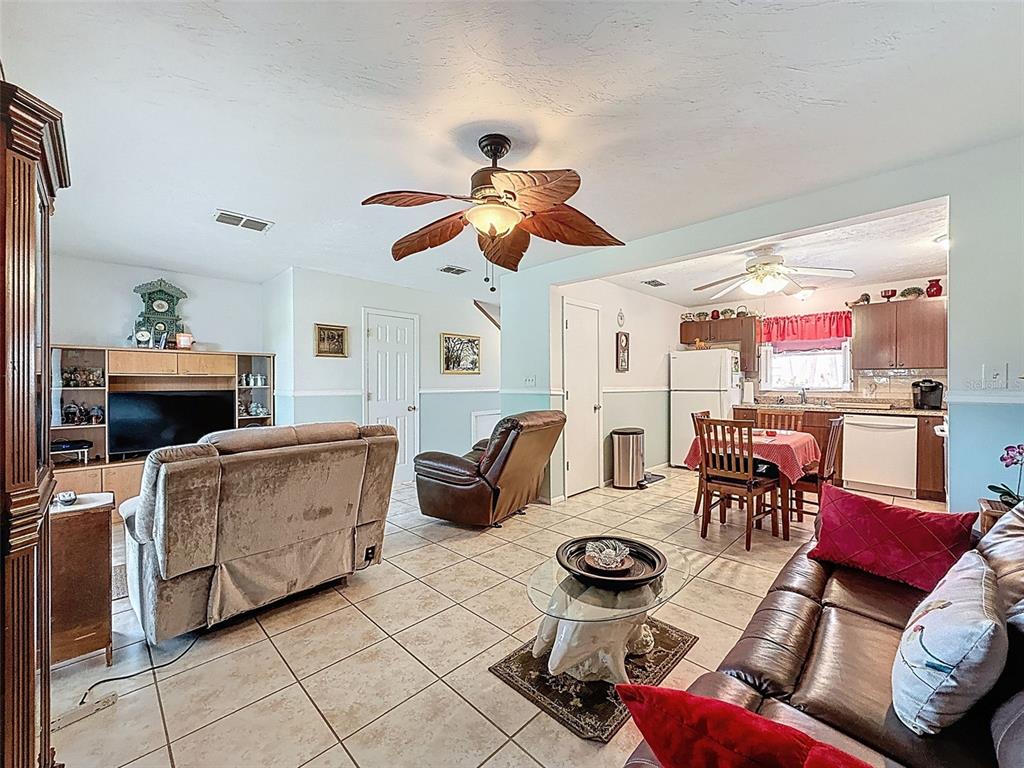 7135 Trenton Place New Port Richey, FL 34653 - Photo 10 of 50 a living room with furniture kitchen view and a chandelier