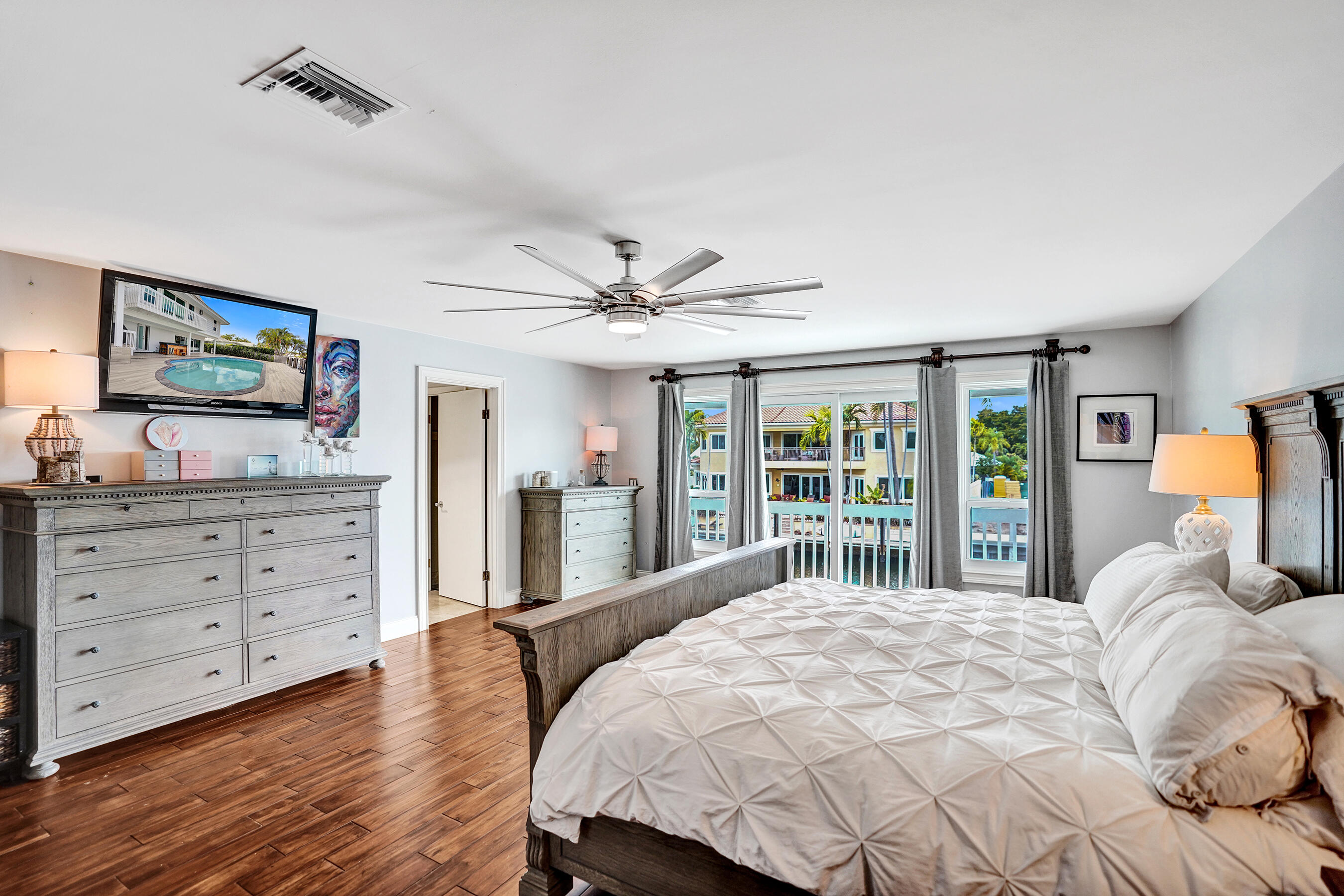 3001 Northeast 47th Street Lighthouse Point, FL 33064 - Photo 17 of 39 a bedroom with a large bed and a flat tv screen on dresser
