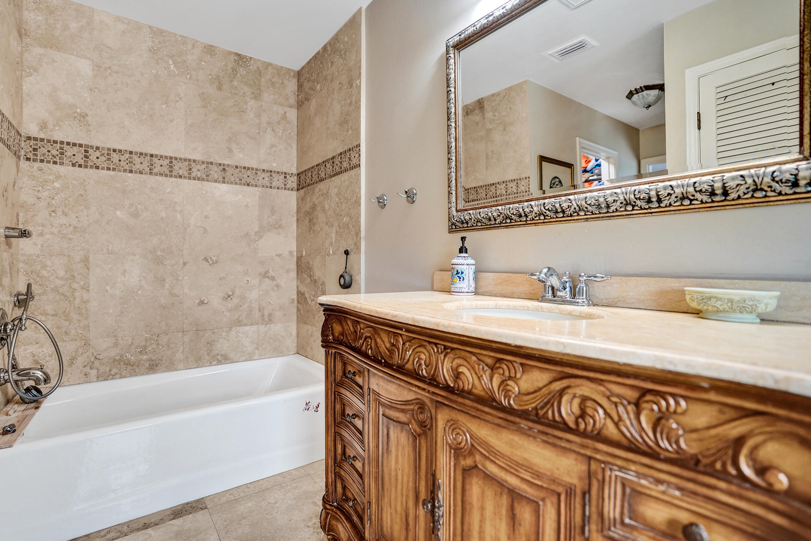 3001 Northeast 47th Street Lighthouse Point, FL 33064 - Photo 21 of 39 a bathroom with a granite countertop sink a mirror a bathtub and shower