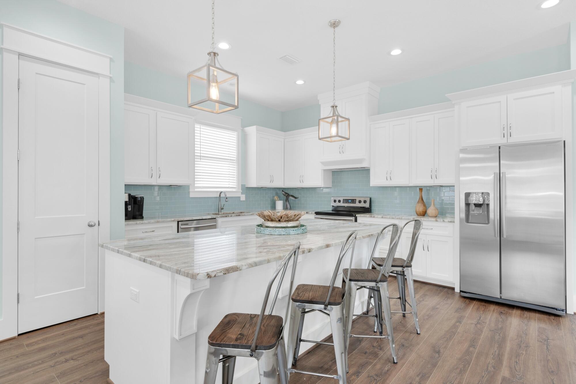 4563 Luke Avenue Destin, FL 32541 - Photo 11 of 37 a kitchen with stainless steel appliances granite countertop a white table and chairs