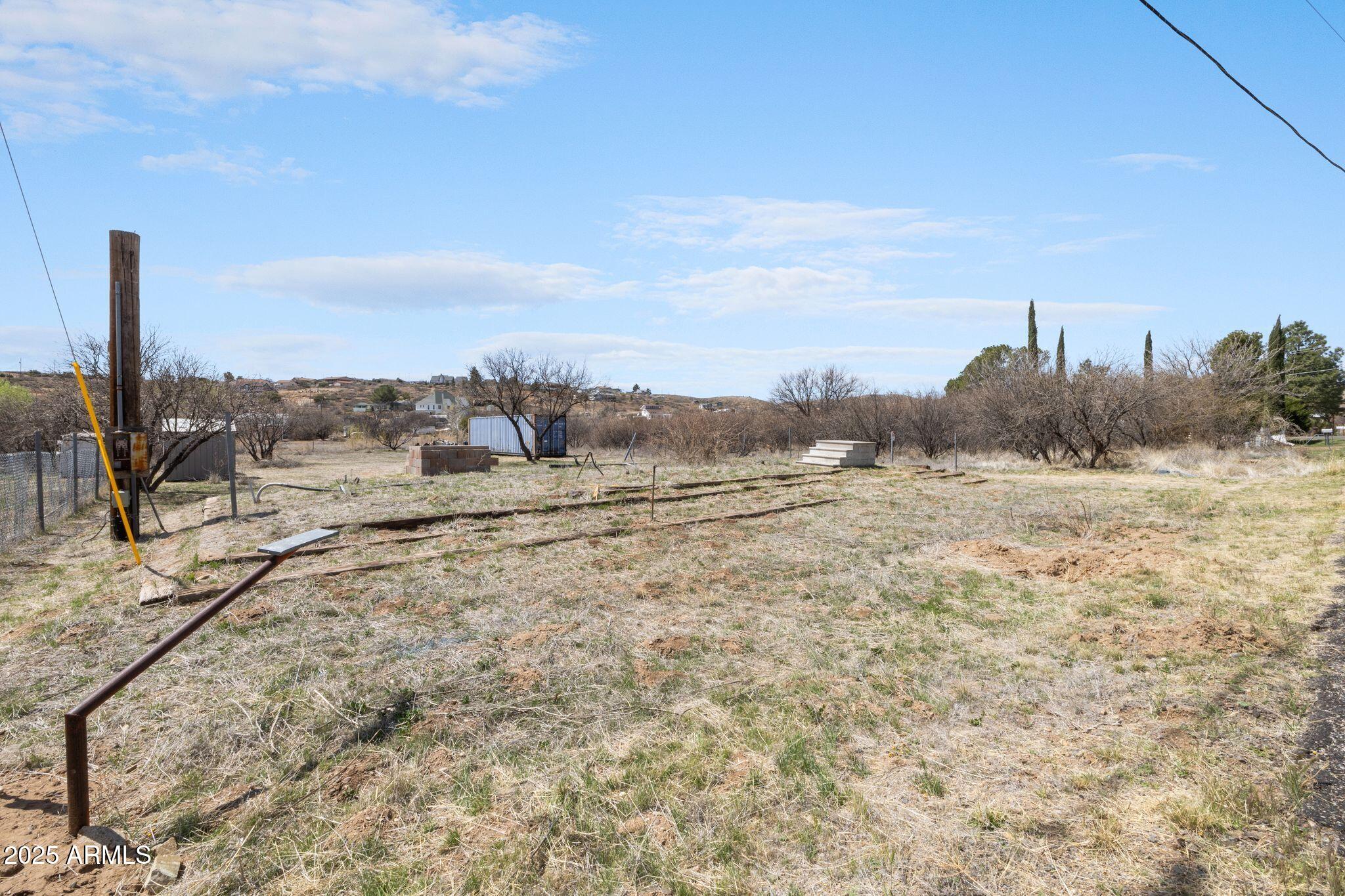 a view of a dry yard with wooden fence