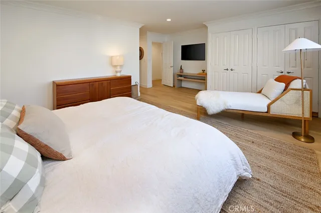 a spacious bedroom with a bed and a flat screen tv