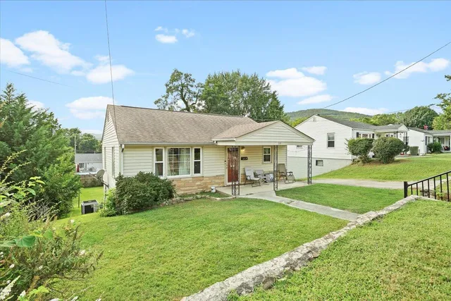 a view of a house with backyard and sitting area