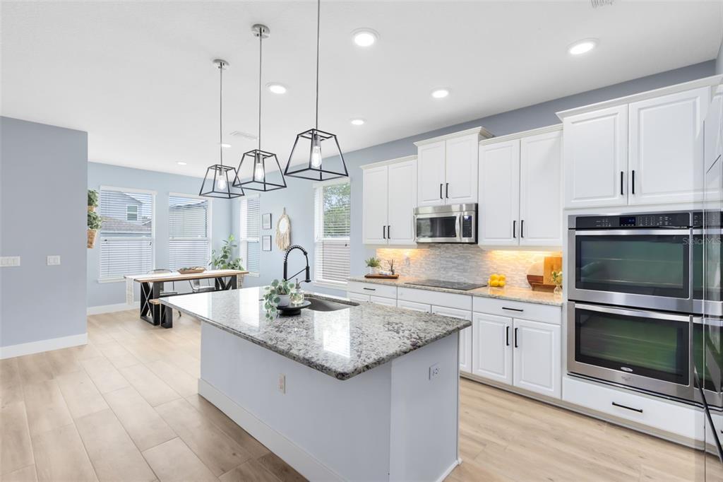 1048 Fountain Coin Loop Orlando, FL 32828 - Photo 17 of 39 a kitchen with stainless steel appliances granite countertop a sink a stove and cabinets