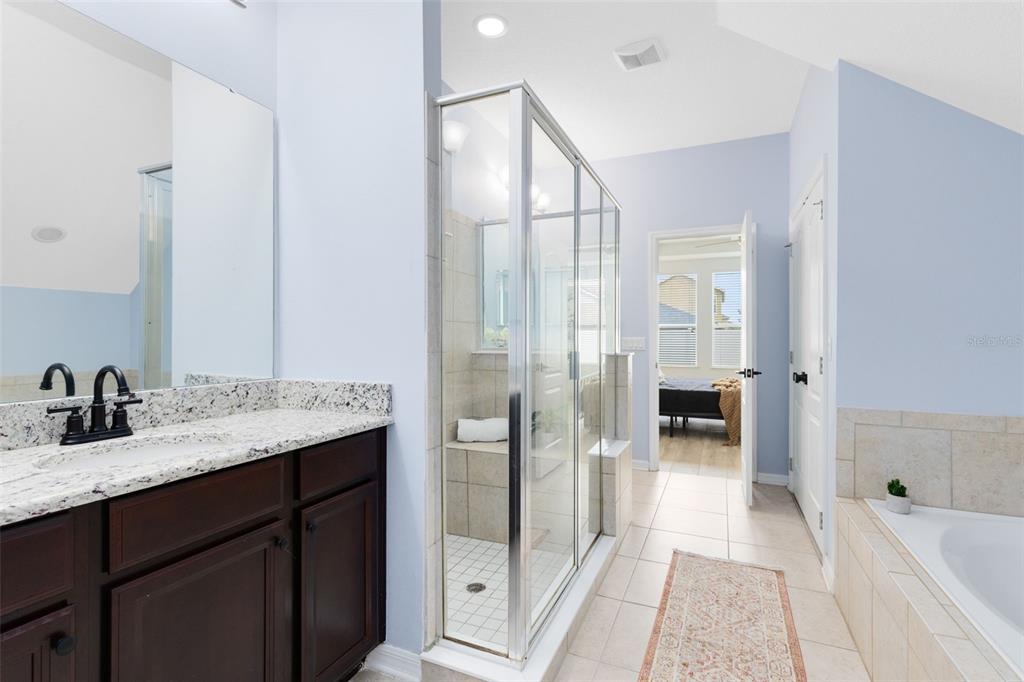 1048 Fountain Coin Loop Orlando, FL 32828 - Photo 22 of 39 a spacious bathroom with a granite countertop sink a toilet a mirror and shower