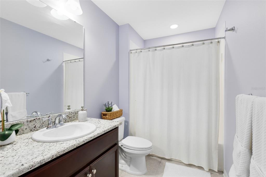 1048 Fountain Coin Loop Orlando, FL 32828 - Photo 27 of 39 a bathroom with a granite countertop sink and a mirror