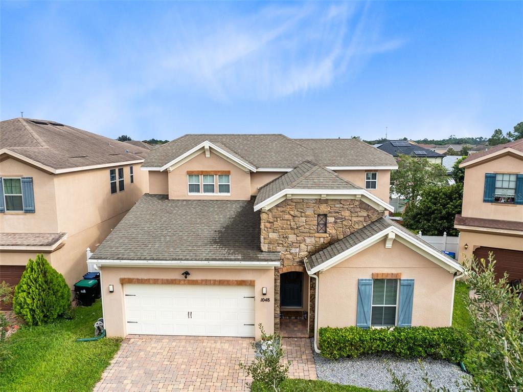1048 Fountain Coin Loop Orlando, FL 32828 - Photo 34 of 39 a front view of a house with a yard and garage